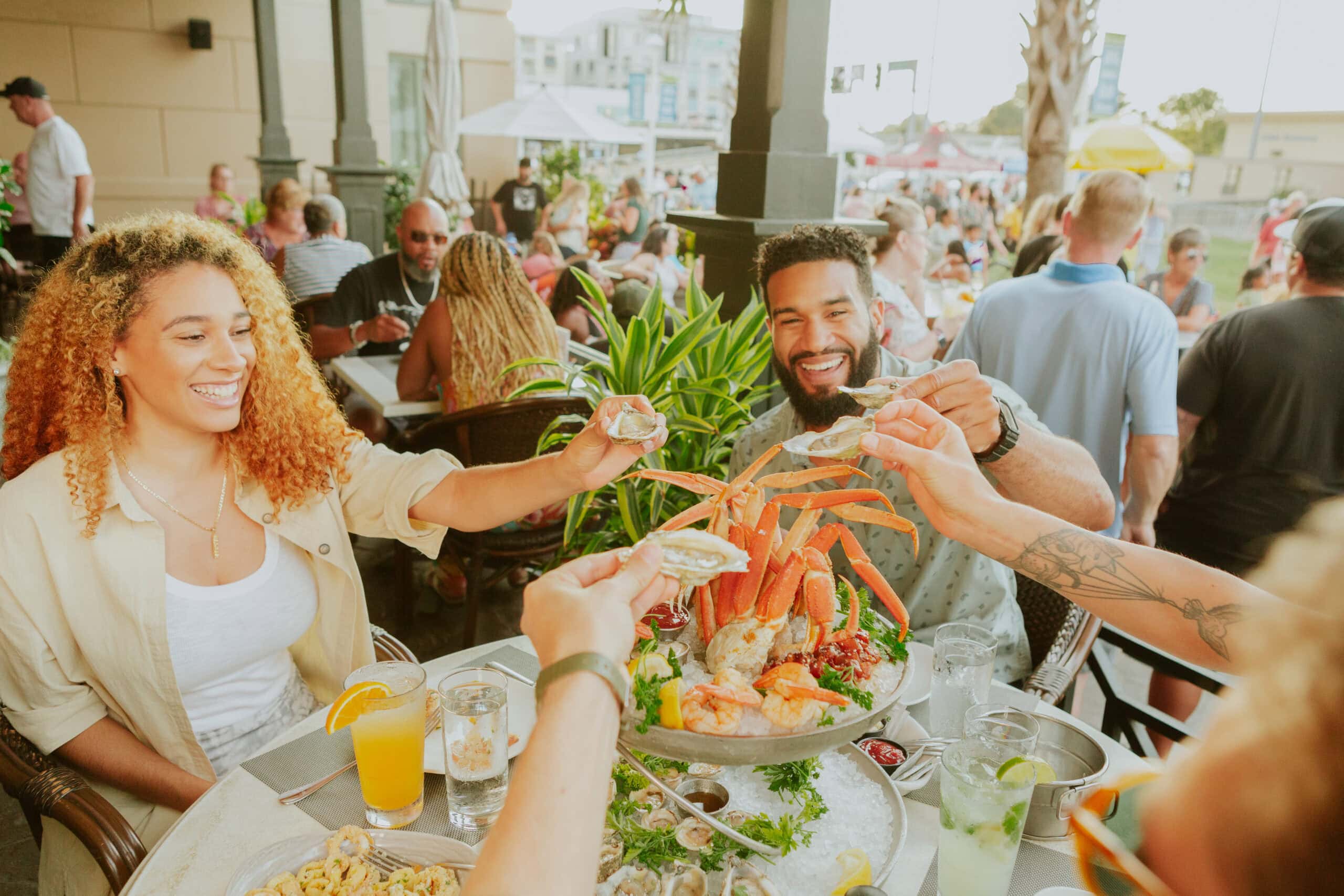 Friends enjoy eating seafood outdoors at Catch 31 restaurant.