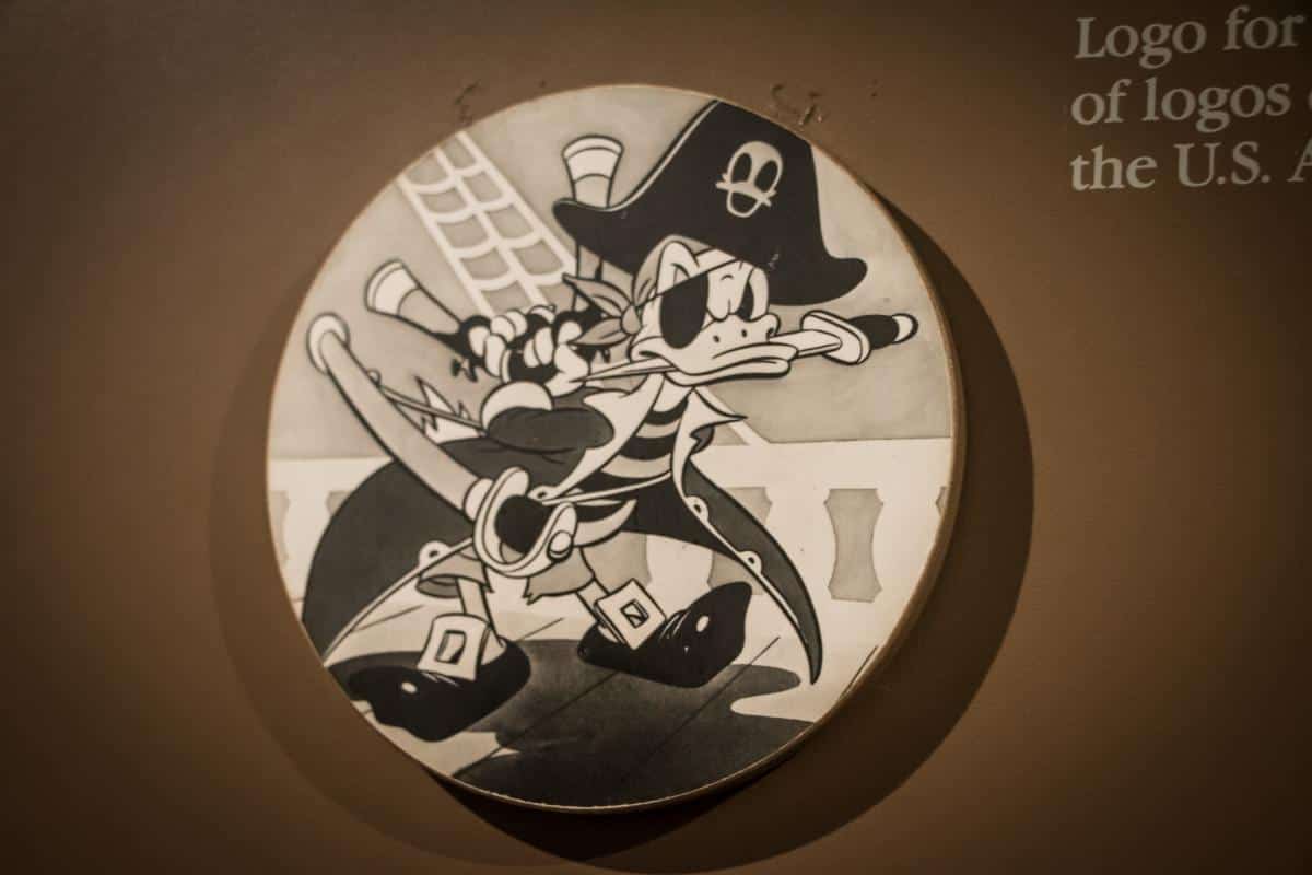 A cartoon duck character dressed as a pirate, with a hat, sword, and eyepatch, on a circular background.