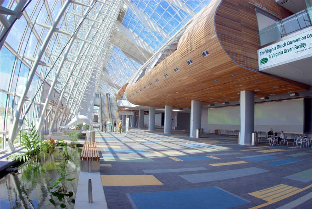 Modern interior of the Virginia Beach Convention Center showcasing large glass windows, wooden accents, and a vibrant carpet design.