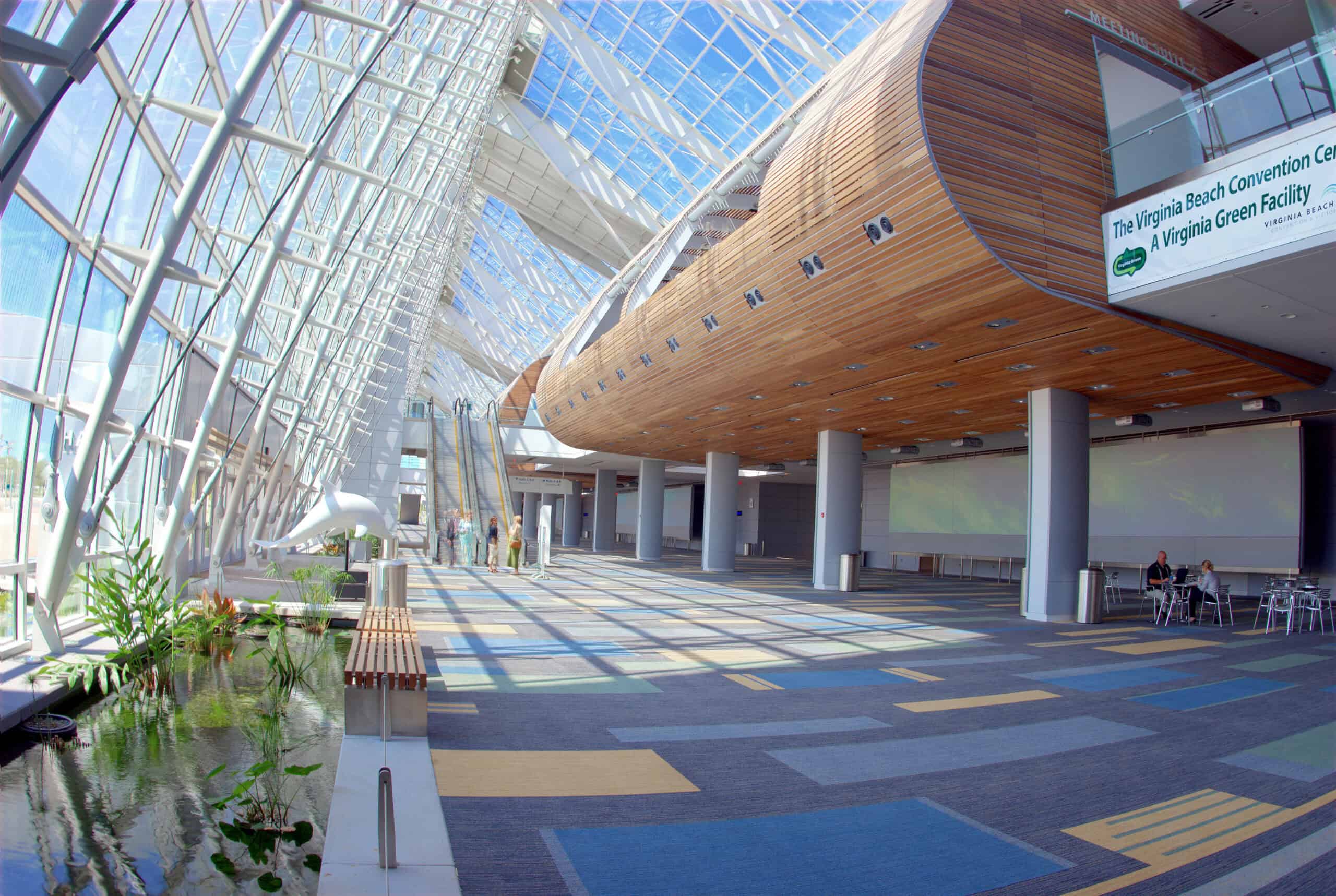 Modern interior of the Virginia Beach Convention Center showcasing large glass windows, wooden accents, and a vibrant carpet design.