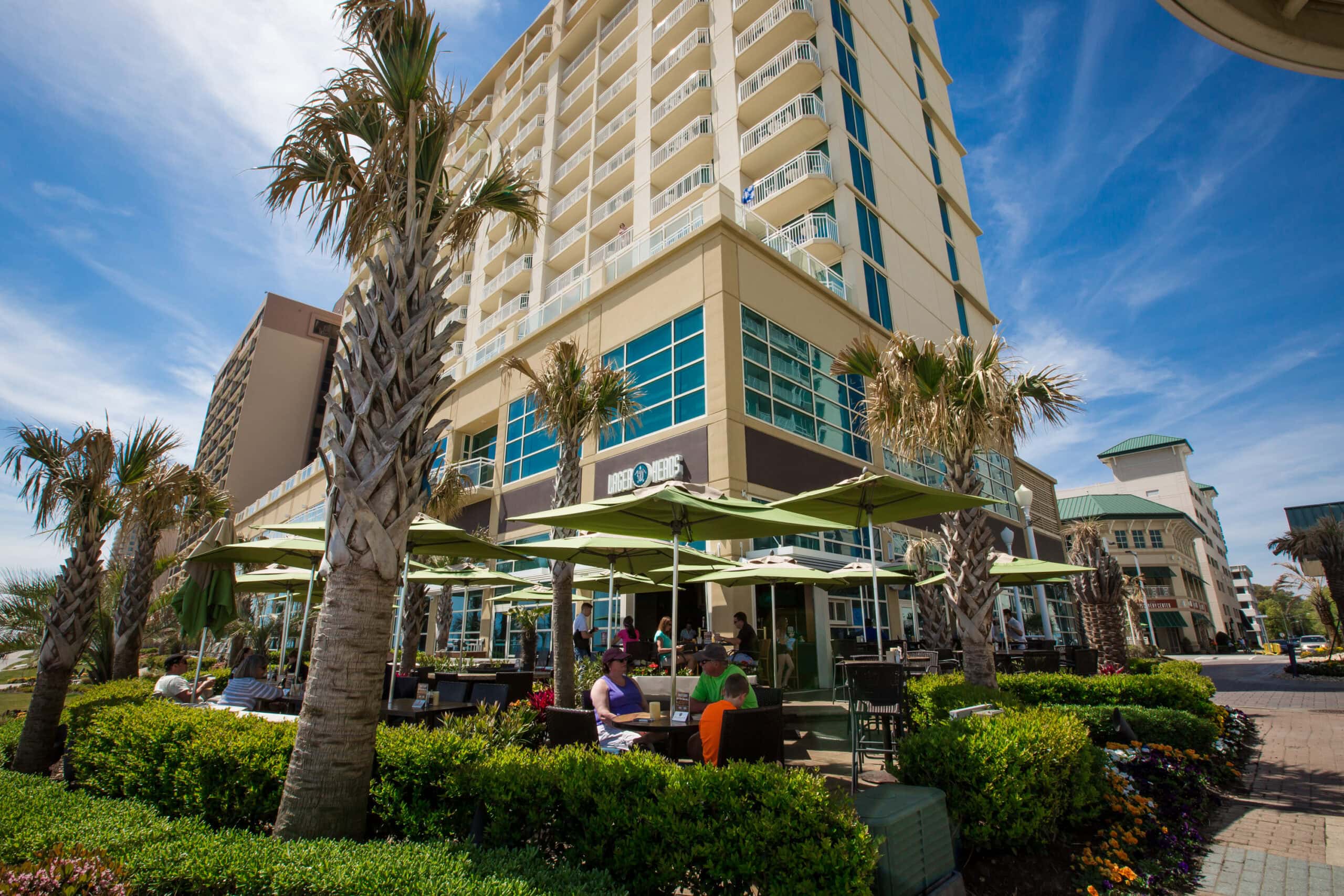 wide image of people sitting outside of a hotel restaurant