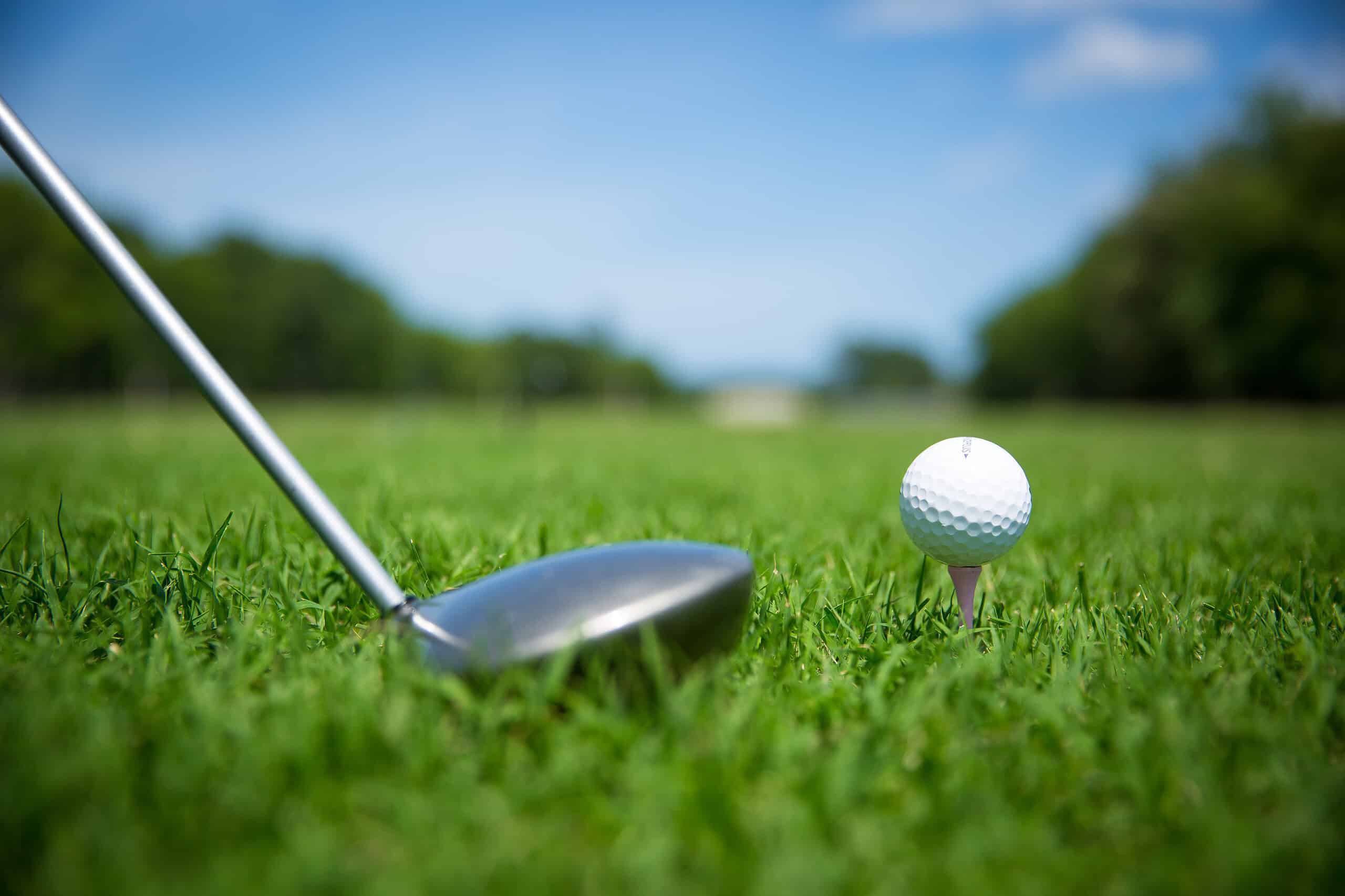 Close up image of Golf Ball and Club in the grass