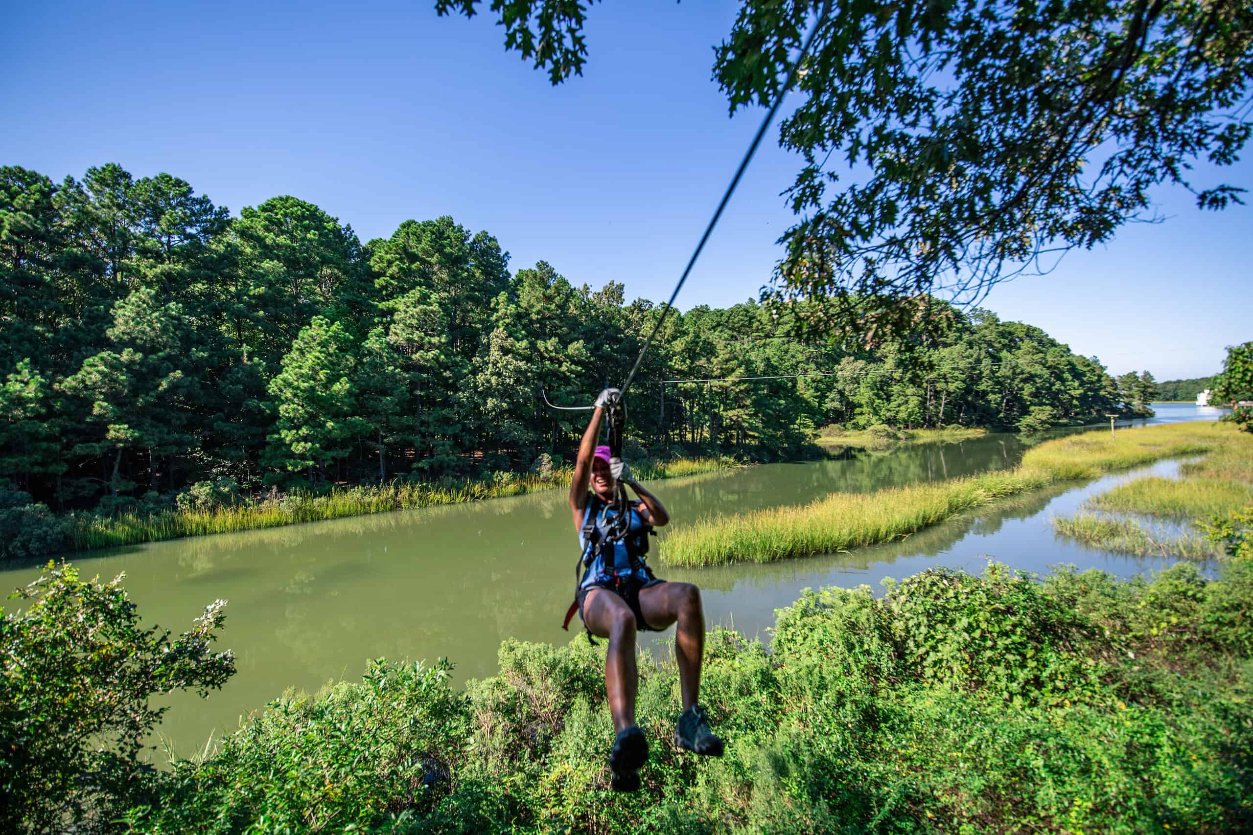 person ziplining over waterway
