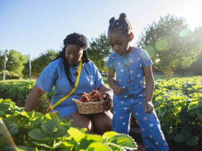 A mother and daughter picking fresh strawberries on a farm in Virginia Beach