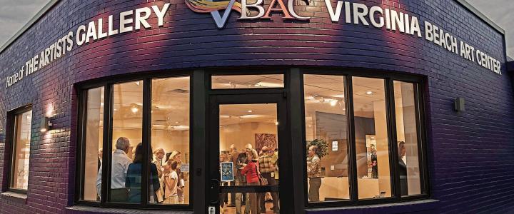 Front view of the Virginia Beach Art Center with people inside. The sign reads 
