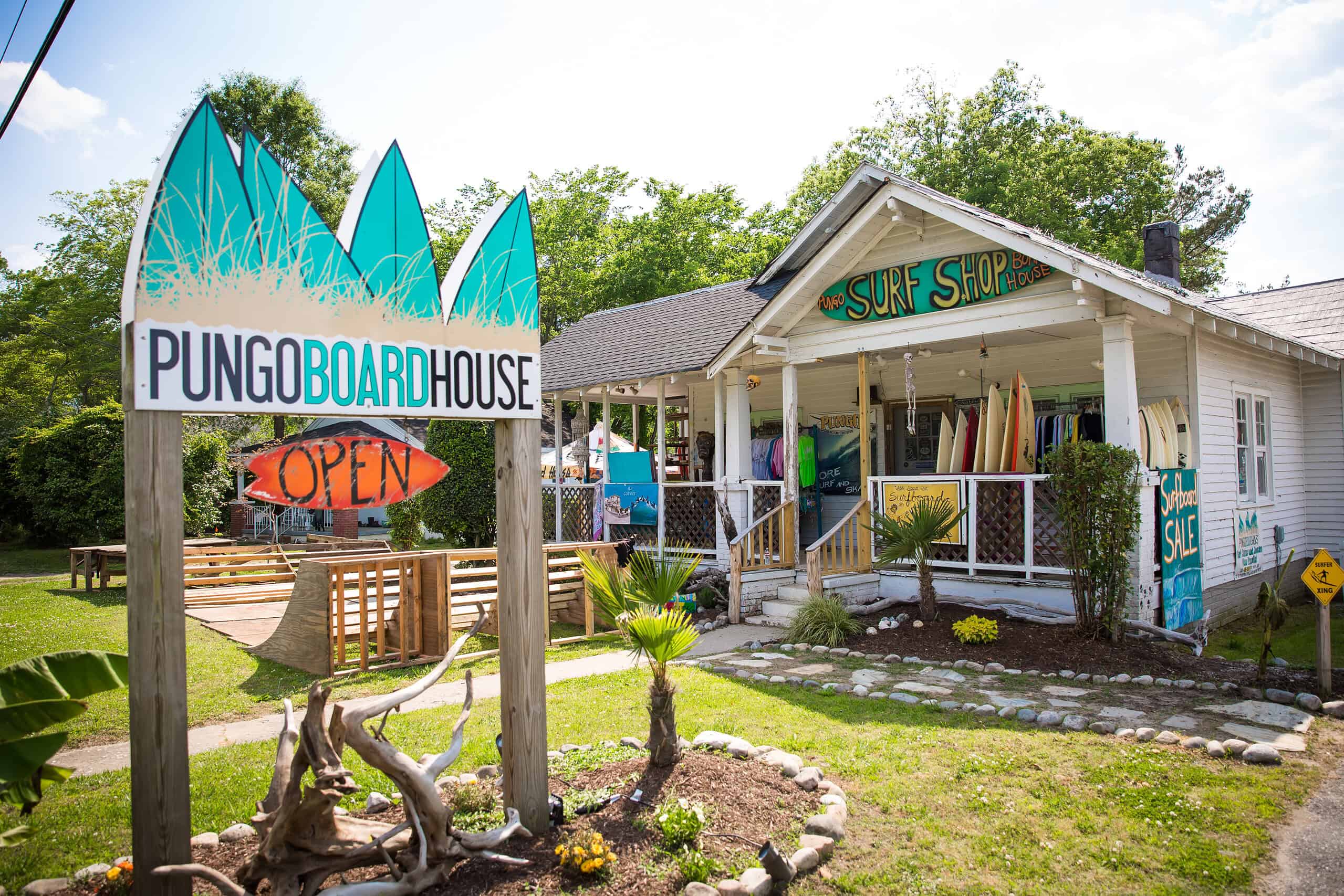 The exterior of Pungo Board House surf shop with an open sign and surf boards in Pungo Virginia Beach.