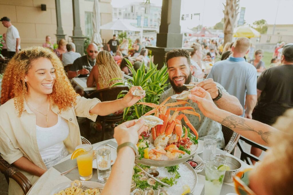 Friends enjoy eating seafood outdoors at Catch 31 restaurant.