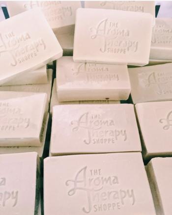 Stacks of rectangular soap bars with "The Aroma Therapy Shoppe" embossed on each.