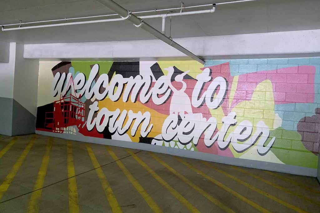 Colorful mural in a parking garage with the text "welcome to town center" in large, bold letters.