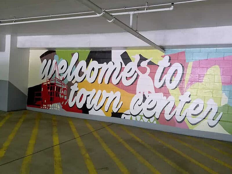 Colorful mural on a parking lot wall with the words 