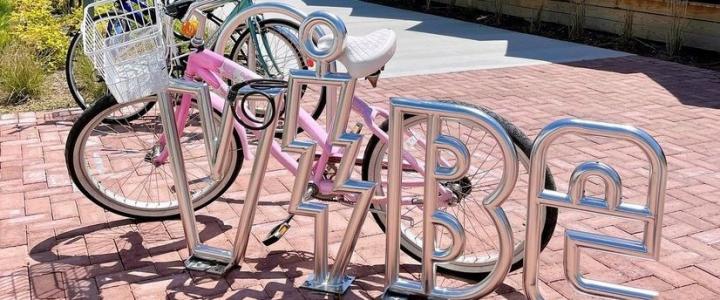 Bicycles parked at a bike rack designed to spell the word 