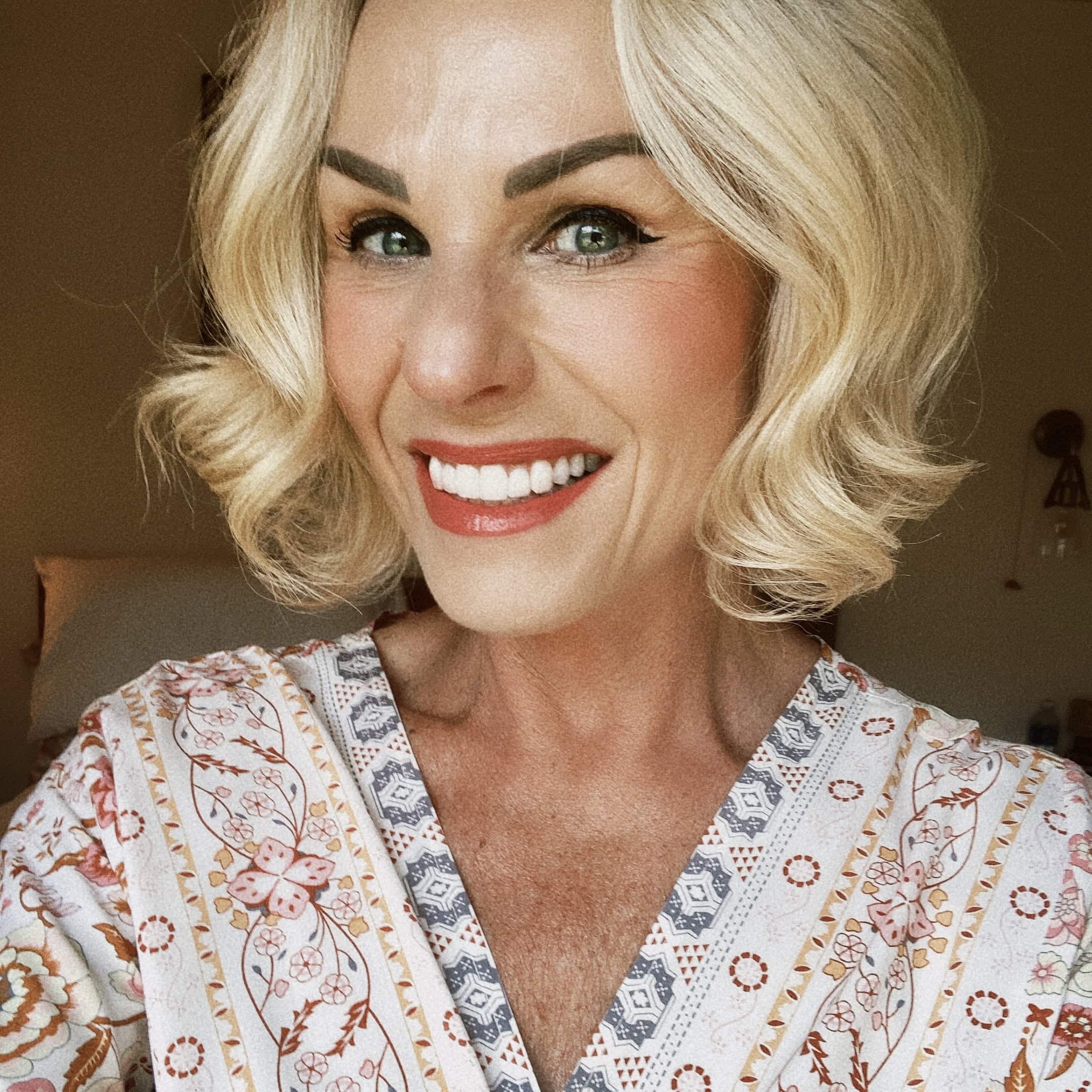 Author Staff member, Staci Amend is smiling with shoulder-length, wavy, blond hair wearing a patterned blouse.