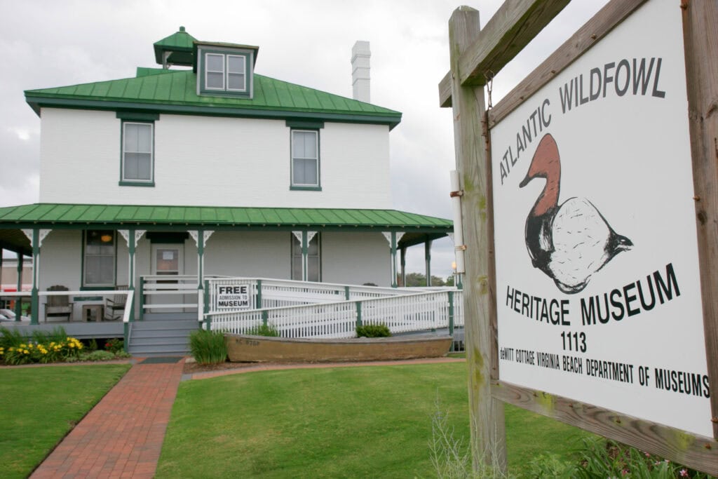 Exterior view of the Atlantic Wildfowl Heritage Museum, featuring a green-roofed building and a sign indicating free admission.