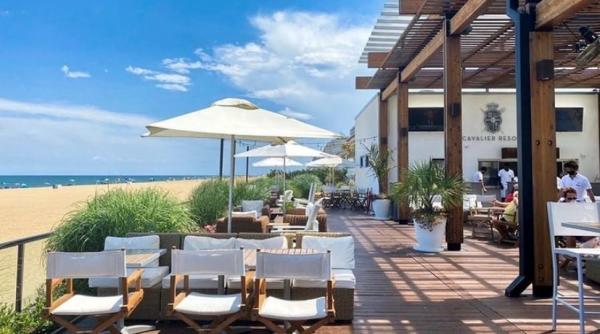 White lounge chairs are outdoors near the oceanfront at The Cavalier Beach Club.