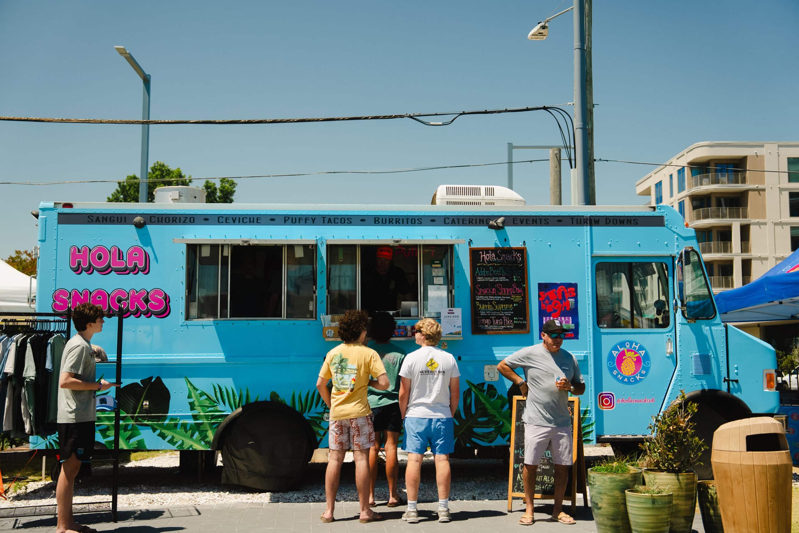 Strandbesucher besuchen einen blauen Food Truck im Atlantic Park Surf in Virginia Beach.